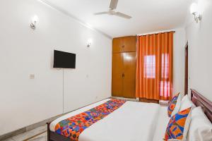 a bedroom with a bed and a flat screen tv at FabExpress Goodwill Homes in New Delhi
