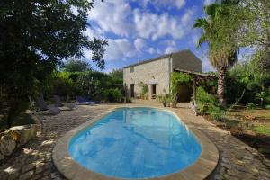 uma piscina em frente a uma casa de pedra em Casa Opuntia em Scicli