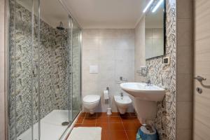 La salle de bains est pourvue de toilettes, d'un lavabo et d'une douche. dans l'établissement Appartamento Standard, à Massafra