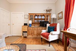 ein Wohnzimmer mit einem Stuhl und einem TV in der Unterkunft Charming Hideaway in Edinburgh City Centre in Edinburgh