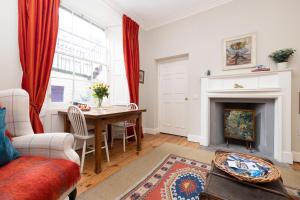 ein Wohnzimmer mit einem Tisch und einem Kamin in der Unterkunft Charming Hideaway in Edinburgh City Centre in Edinburgh