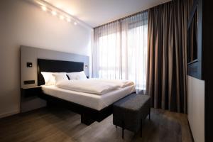 Tempat tidur dalam kamar di GINN Apartment-Hotel Stuttgart-Esslingen