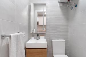 biała łazienka z umywalką i toaletą w obiekcie Bungalow Carpe Diem Capri w mieście Maspalomas +20 zdjęć