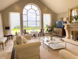 a living room with a fireplace and a large window at LakeviewLodge in Wicklow