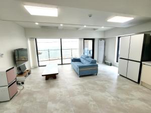 a large living room with a couch and a tv at Storm Wind Poolvilla in Ulsan