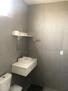a bathroom with a white sink and a toilet at Casa privado com 3 quartos e piscina in Logradouro