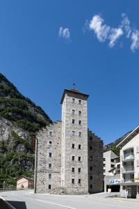 um edifício de pedra alto com uma cruz em cima em Hotel Restaurant Stockalperturm em Ruden