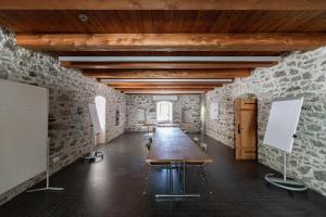 a long table in a room with a stone wall at Hotel Restaurant Stockalperturm in Ruden