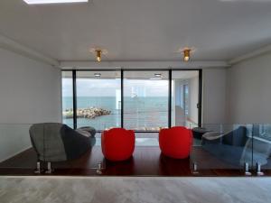 a living room with chairs and a view of the ocean at Storm Wind Poolvilla in Ulsan