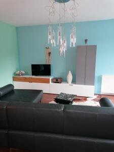 a living room with a black couch and chandeliers at Appartement Baju in Bad Urach