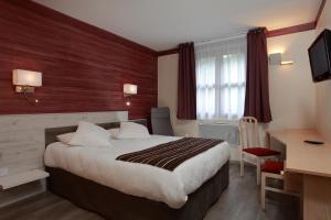 een hotelkamer met een bed en een bureau bij Logis Le Luth in Mirecourt