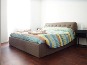 un letto con una coperta in una stanza di Casa Nina a Sondrio