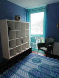 um quarto com uma cama, uma cadeira e uma janela em Appartement Baju em Bad Urach