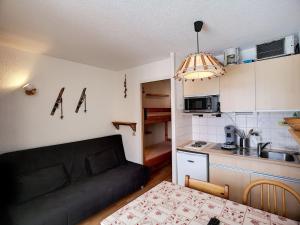 a living room with a couch and a kitchen at Studio montagne 3 pers aux Menuires, ski aux pieds - FR-1-178-305 in Les Menuires