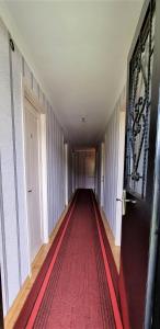 an empty hallway with a red carpet and a door at Betegi Guest House in Mestia