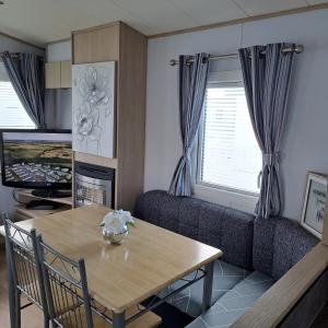 a living room with a table and a couch at CJ & Daisies Holiday Home in Prestatyn