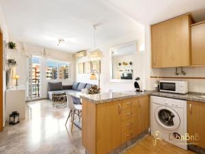 a kitchen and living room with a washer and dryer at Apartment with pool and private parking near Aqua Mijas in Fuengirola