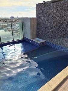 a swimming pool on top of a building at Grande Apartamento Beira-Mar 2/4 Pajuçara in Maceió