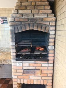 a brick oven with some food inside of it at Grande Apartamento Beira-Mar 2/4 Pajuçara in Maceió
