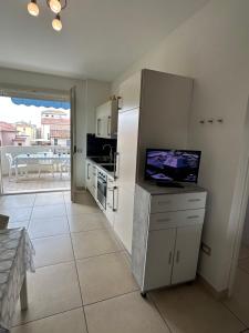 a kitchen with a refrigerator and a tv on a counter at RICCIO BLU pochi passi dal mare in Alba Adriatica
