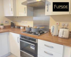 a kitchen with two pots and pans on a stove at Three Bedroom Semi Detached House By Flipside Property Aylesbury Serviced Accommodation & Short Lets With Wifi & Parking in Aylesbury