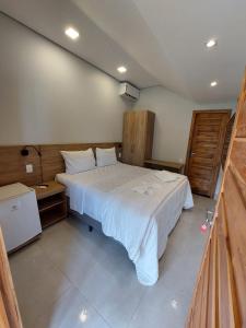 a bedroom with a large white bed in a room at Pousada e Restaurante Valle dos Ventos in Chapada dos Guimarães