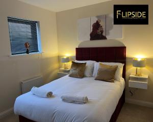 a bedroom with a large bed with two towels on it at Three Bedroom Semi Detached House By Flipside Property Aylesbury Serviced Accommodation & Short Lets With Wifi & Parking in Aylesbury
