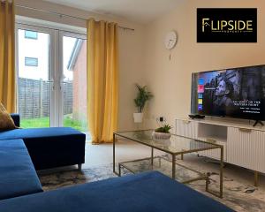 a living room with a blue couch and a tv at Three Bedroom Semi Detached House By Flipside Property Aylesbury Serviced Accommodation & Short Lets With Wifi & Parking in Aylesbury