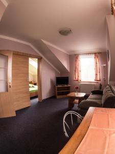 uma sala de estar com um sofá e uma mesa em Hotel Holzbecher Ratibořice em Česká Skalice