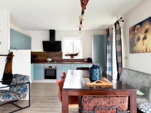 eine Küche mit Tisch und ein Esszimmer in der Unterkunft Holiday home with sauna, outdoor spa in Earnewâld