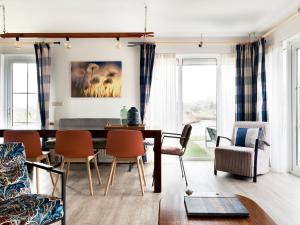 ein Wohnzimmer mit Esstisch und Stühlen in der Unterkunft Holiday home with sauna, outdoor spa in Earnewâld