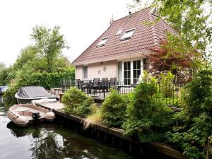 ein Haus mit zwei Booten im Wasser in der Unterkunft Holiday home with sauna, outdoor spa in Earnewâld