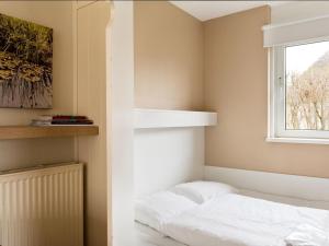 a bedroom with a bed and a window at Bungalow near De Alde Feanen with Spa in Earnewâld