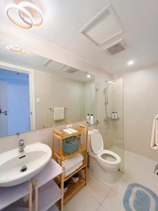 a bathroom with a sink and a toilet and a shower at GBU's Studio with Balcony at Azure North Pampanga in San Fernando