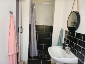 een badkamer met een wastafel, een spiegel en een bad bij Trendy Johannesburg Cottages in Johannesburg