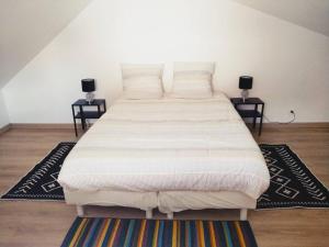 a large bed in a room with two tables at L'Embrun de la Baie de Somme in Saint-Valery-sur-Somme