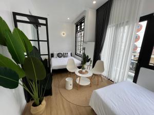 um quarto com 2 camas, uma mesa e cadeiras em ANH’s HOUSE em Hue