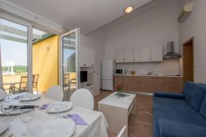 ein Wohnzimmer mit einem Tisch und einem blauen Sofa in der Unterkunft Apartments Faro in Bašanija