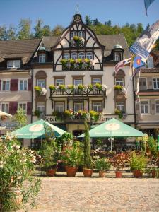 ein Gebäude mit Pflanzen und Sonnenschirmen davor in der Unterkunft Hotel Restaurant Krone in Wolfach