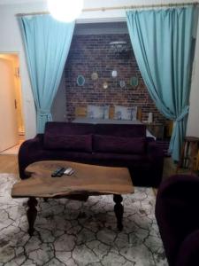 a living room with a couch and blue curtains at Nelly Guesthouse in Istanbul