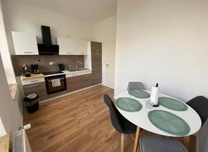 a dining room with a table and chairs and a kitchen at Südstrand nahe Eigentumswohnung mit Stil in Wilhelmshaven