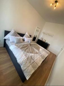 a bedroom with a large bed with white sheets and pillows at Südstrand nahe Eigentumswohnung mit Stil in Wilhelmshaven