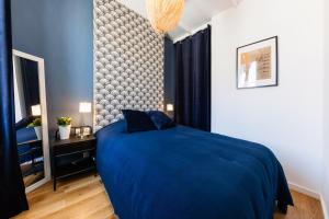 ein Schlafzimmer mit einem blauen Bett und einer Wand in der Unterkunft La Bonne Mère-Vue Notre-Dame de La Garde in Marseille