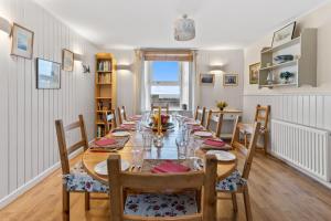 a dining room with a long table and chairs at Finest Retreats - Harbour House in Craster