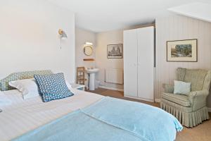 a bedroom with a large bed and a chair at Finest Retreats - Harbour House in Craster