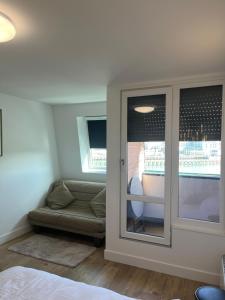Pokój z drzwiami z kanapą i oknem w obiekcie Mon balcon face à la mer - les Marinas Deauville w mieście Deauville