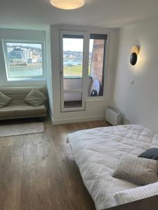 sypialnia z dużym łóżkiem i oknem w obiekcie Mon balcon face à la mer - les Marinas Deauville w mieście Deauville