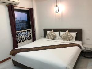 a bedroom with a large bed with a window at Gusto House in Chiang Mai