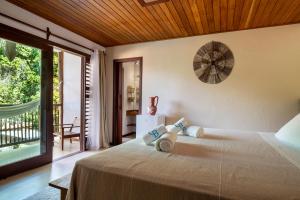Cottage Bahia في ارايال دايودا: غرفة نوم مع سرير مع ساعة على الحائط