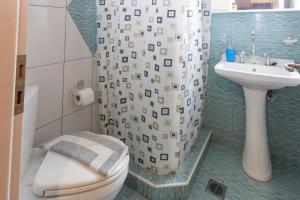 a bathroom with a toilet and a sink and a shower at Paradeisos in Kardamyli +55 photos